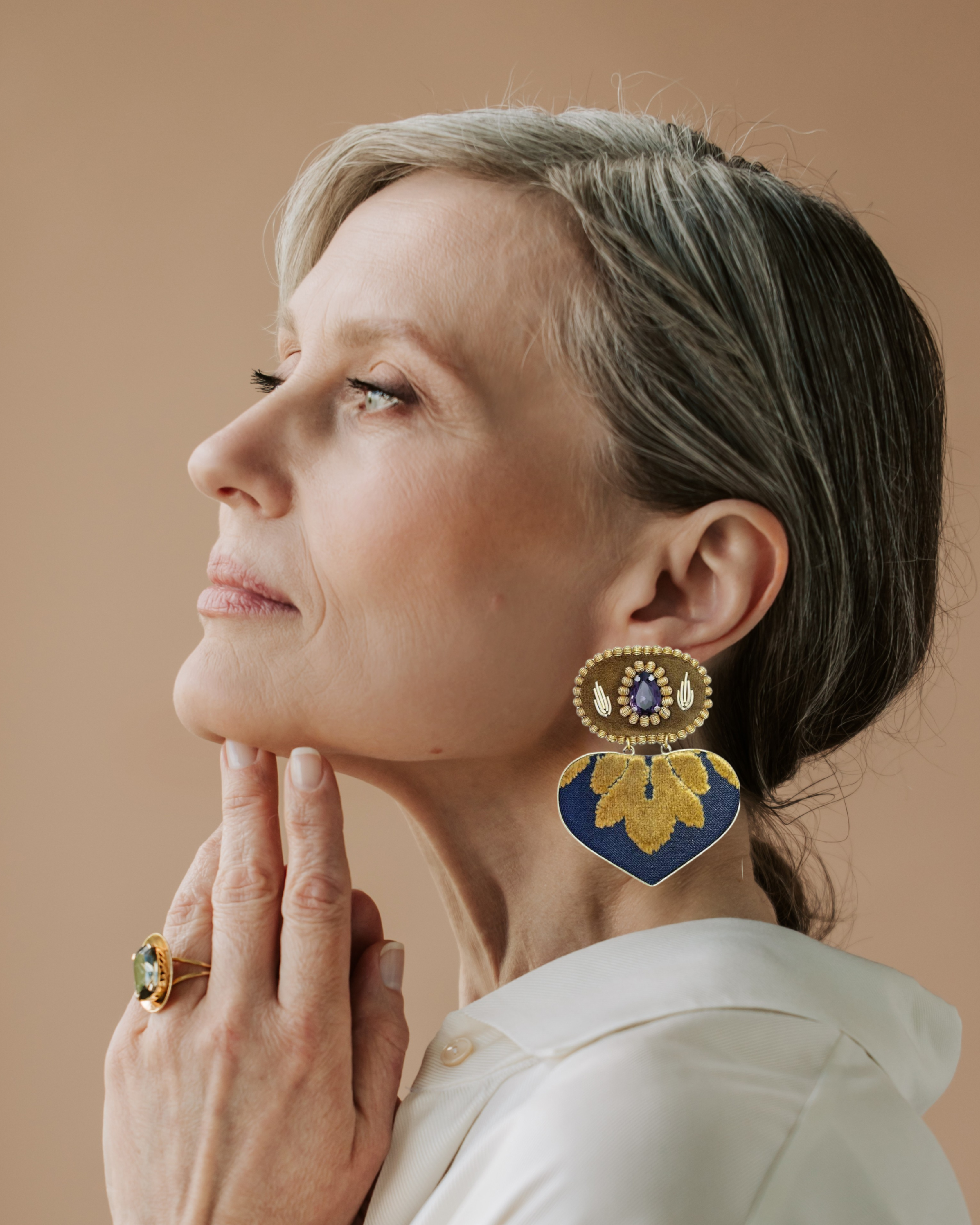 Model wearing handmade statement earrings with navy and gold embroidery and crystal embellishment