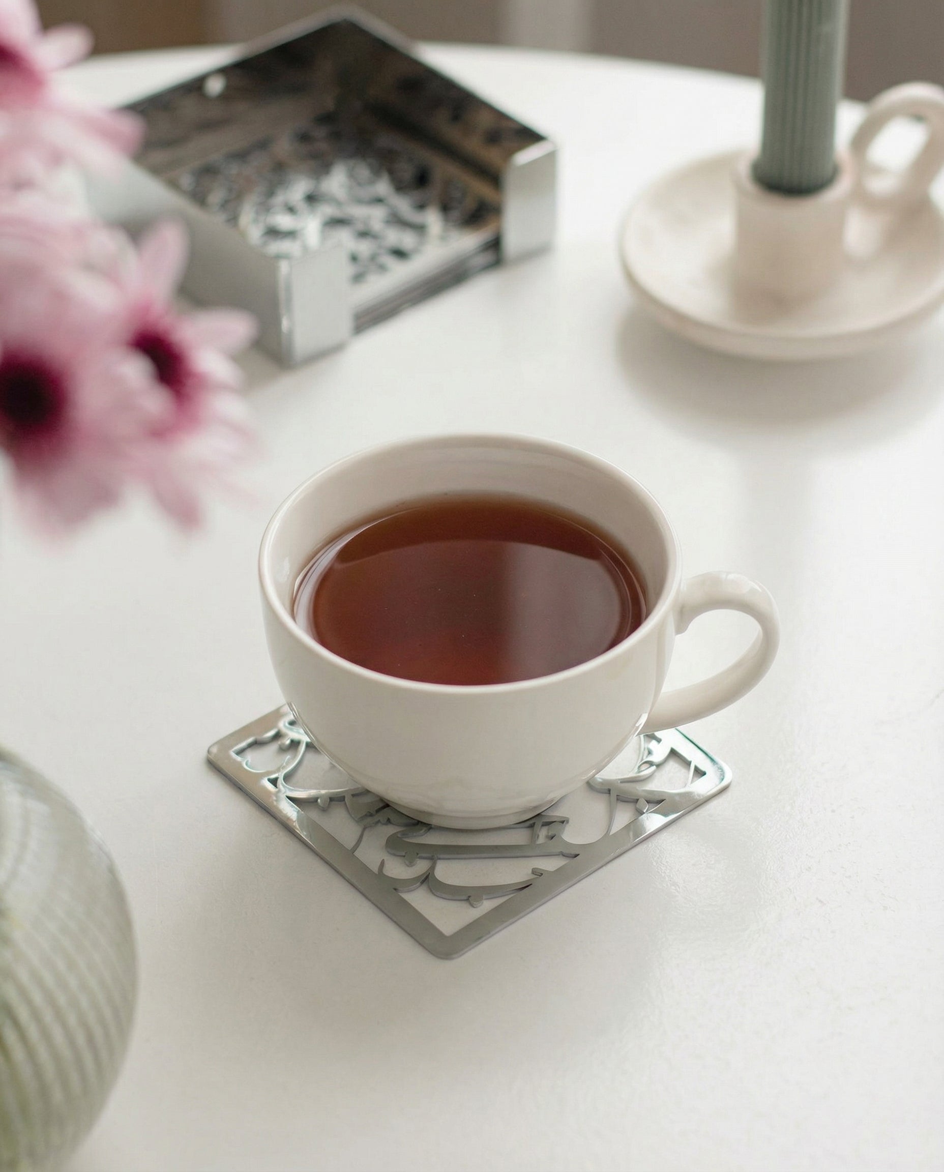 Silver metal calligraphy coaster under tea cup