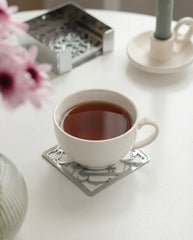 Silver metal calligraphy coaster under tea cup