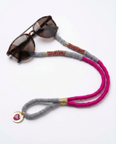 Sunglasses with a colorful beaded eyeglass holder on a white background