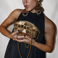 Model holding artisan Persian-inspired designer bag