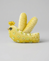 Corn sculpture shaped like a bird with a crown on a gray background