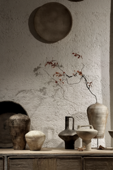Minimalist handmade vases with dry branches in artistic home setting