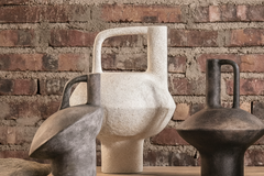 Stone-textured decorative vases with handles on wood cabinet