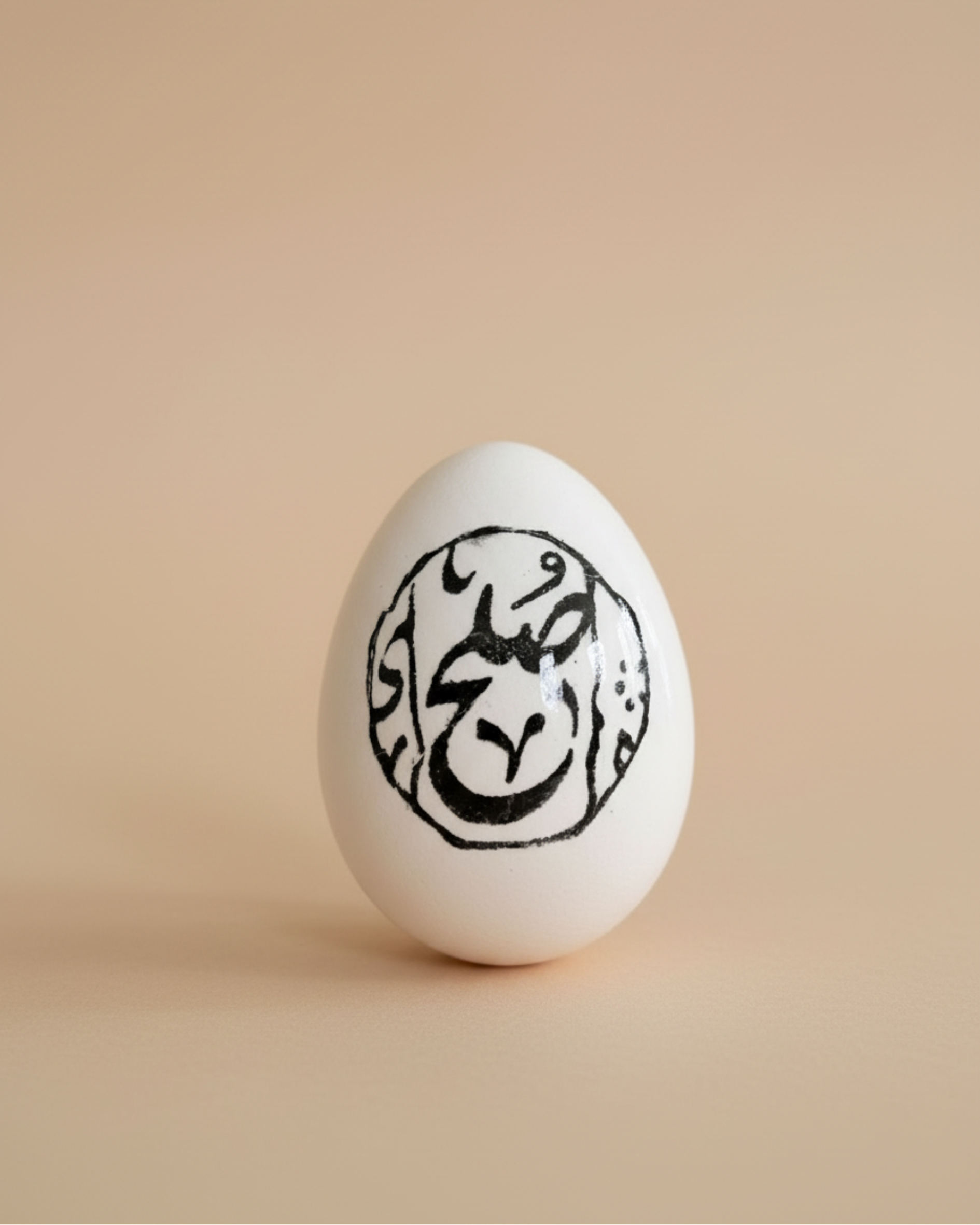 White egg with black decorative design on a beige background