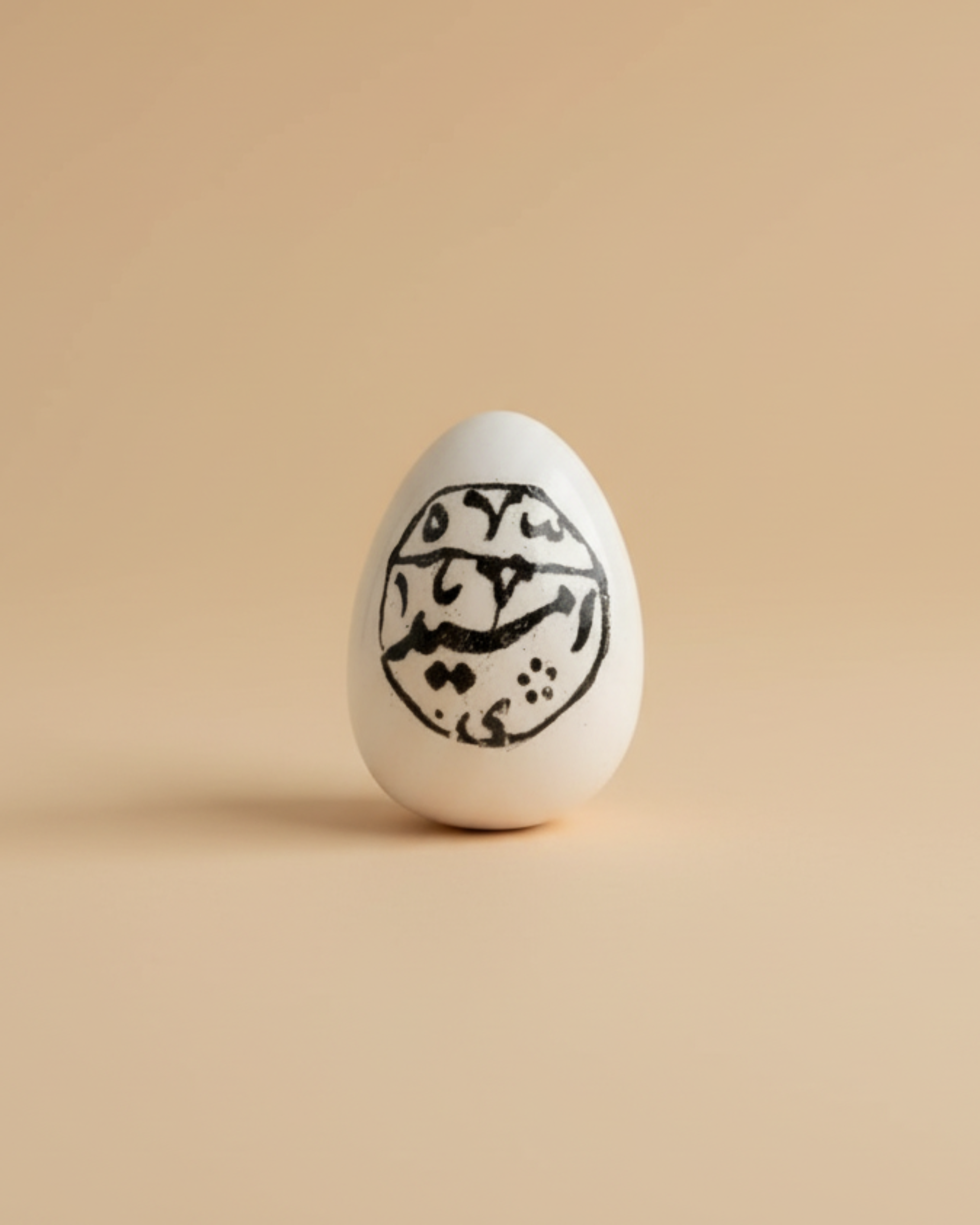 White egg with black Arabic calligraphy on a beige background