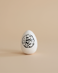 White egg with black design on a beige background