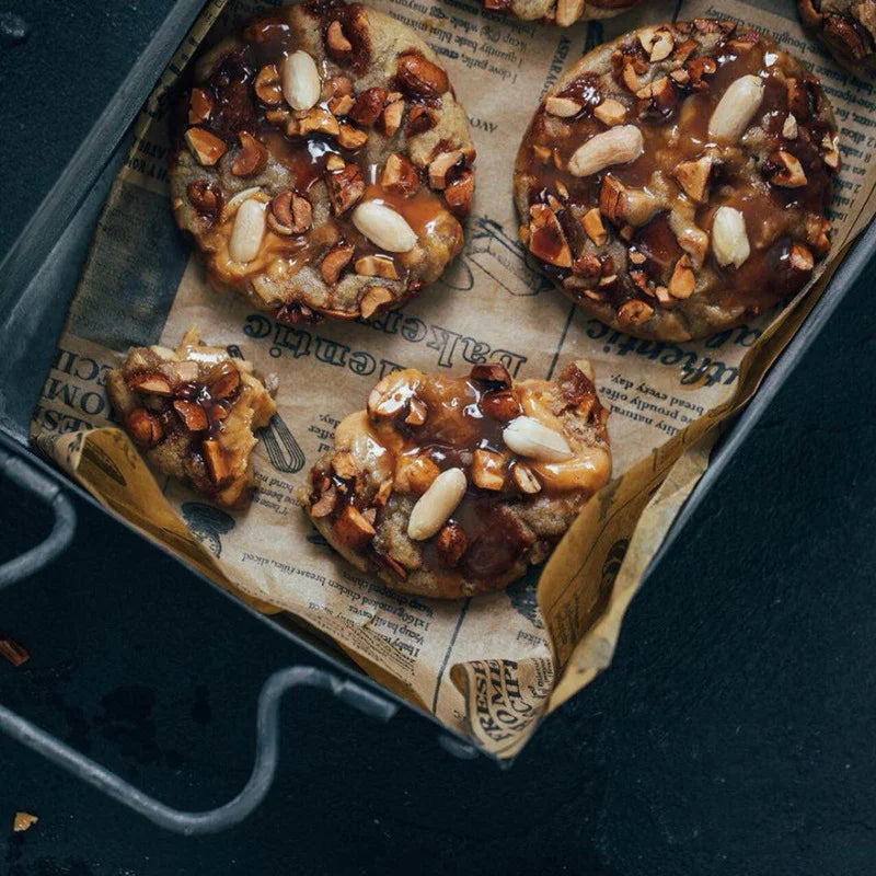 Cookies with nuts on a baking tray lined with newspaper