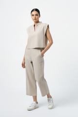 Relaxed-fit beige linen set with structured shoulders and wide-leg pants, modeled in a bright studio setting