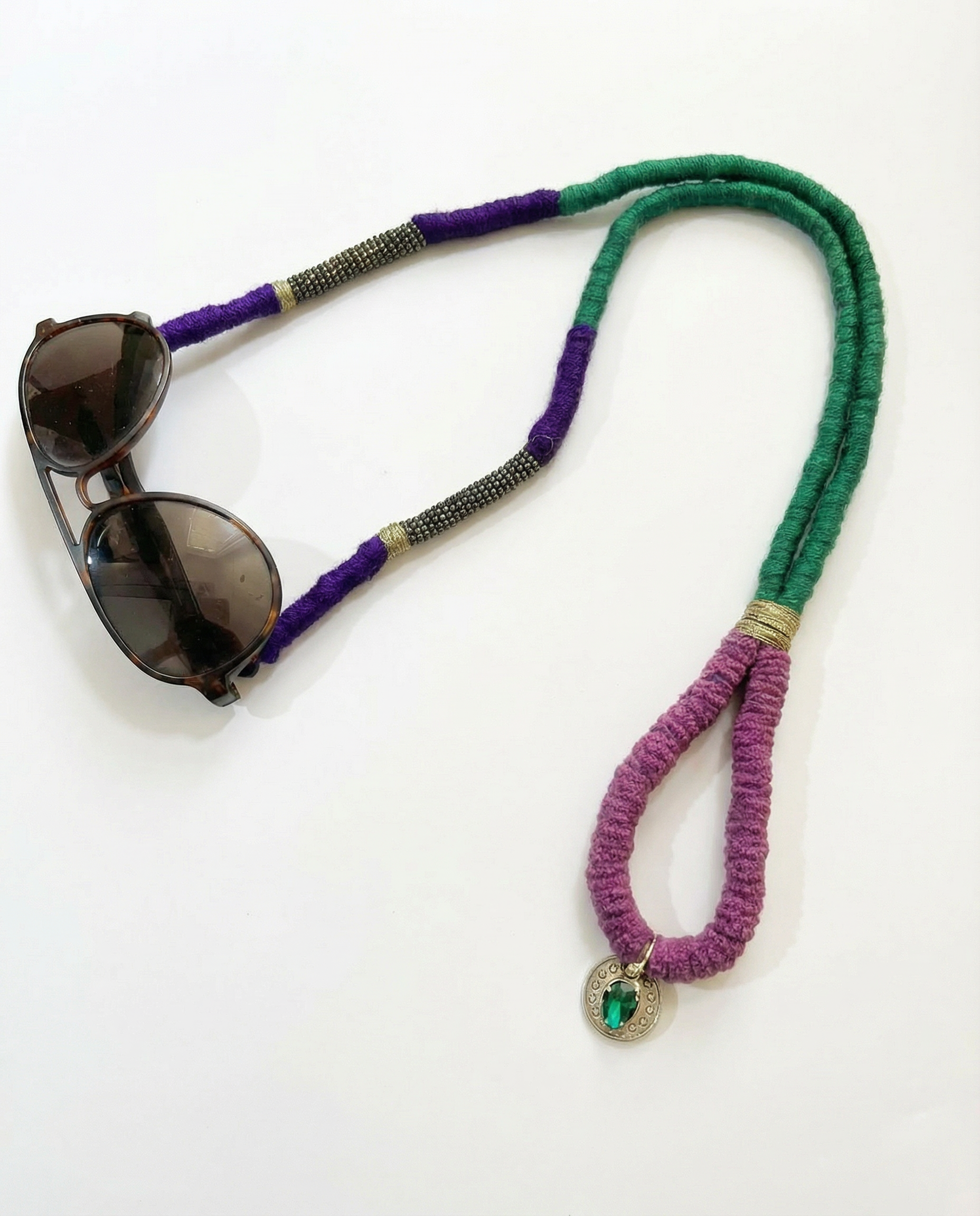 Sunglasses on a colorful cord with a heart charm on a white background