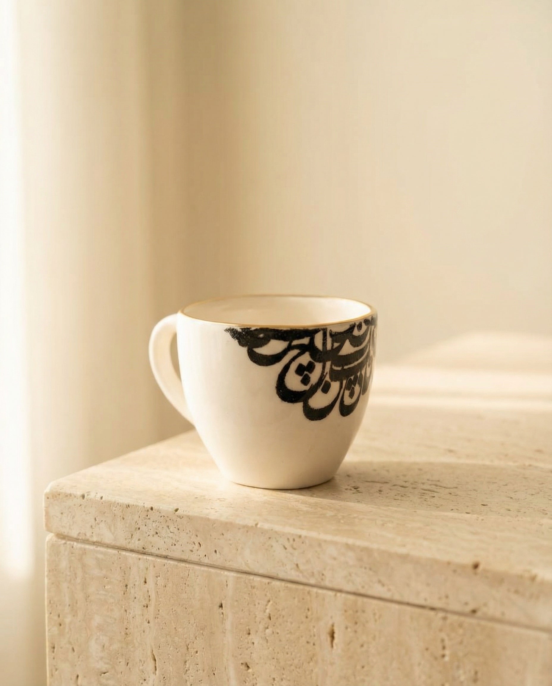 White mug with black text on a wooden surface against a beige wall
