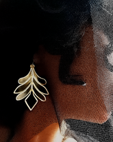 Silver-toned leaf earrings crafted from plexiglass with sculptural design