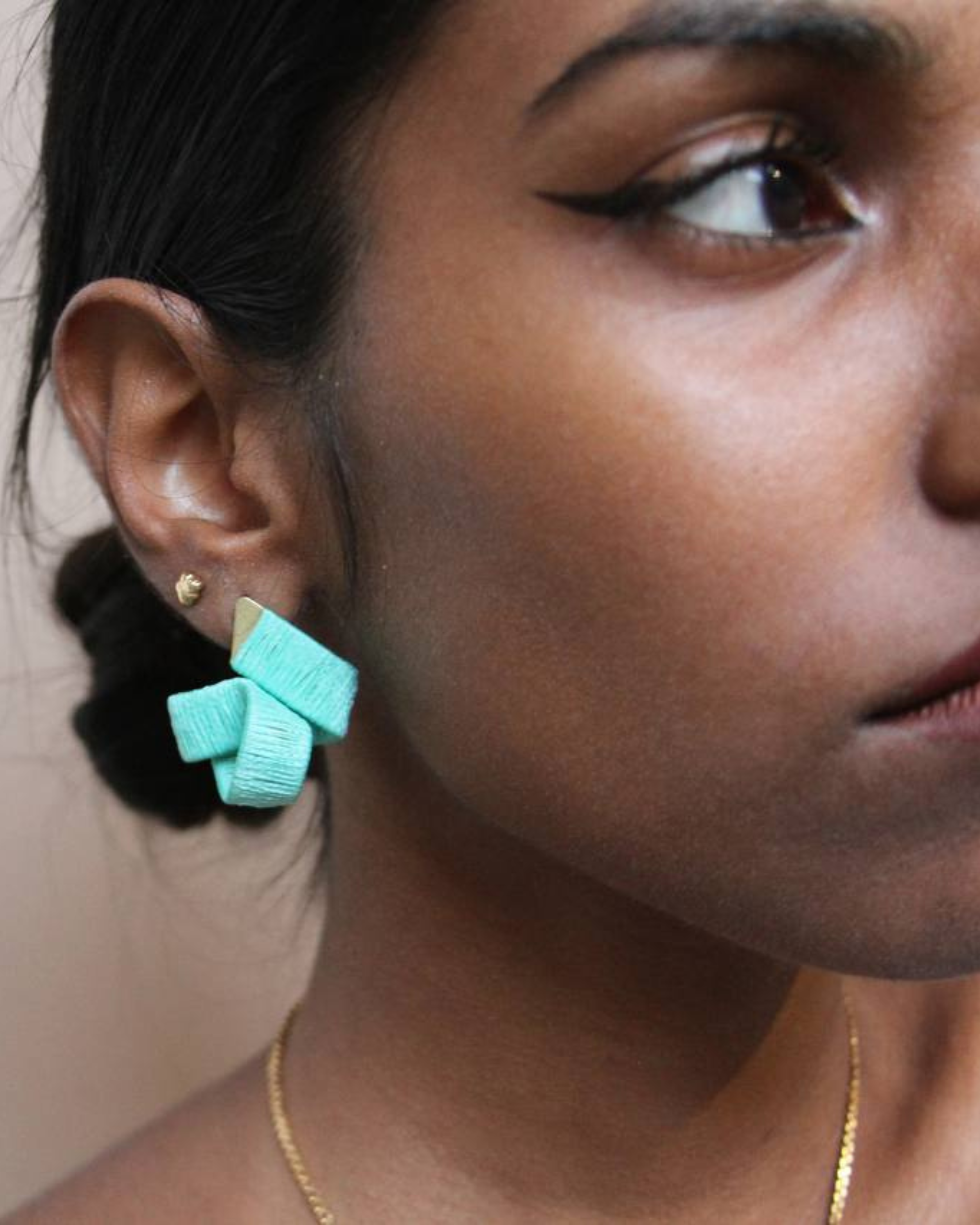 Model wearing statement handmade mint green knot earrings