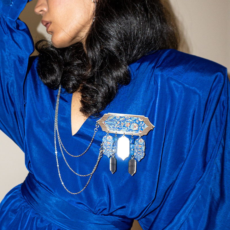 Artistic statement brooch with dangling motifs