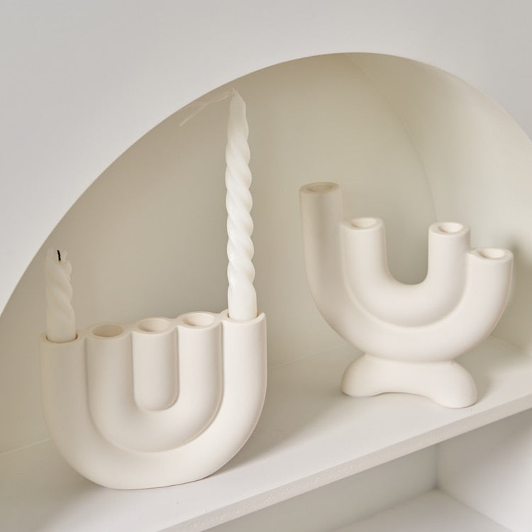 Sculptural white ceramic candlestick holder on table