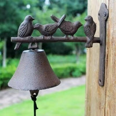 Vintage bird-shaped cast iron doorbell mounted on wall