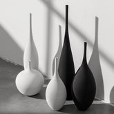 Minimalist black and white ceramic vases in sunlight