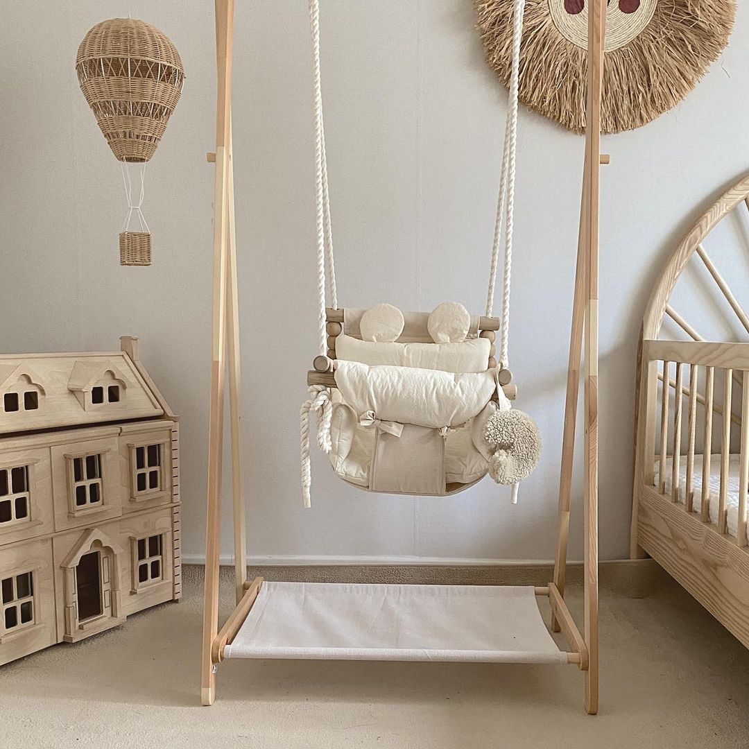 Indoor baby swing hanging in neutral Scandinavian nursery