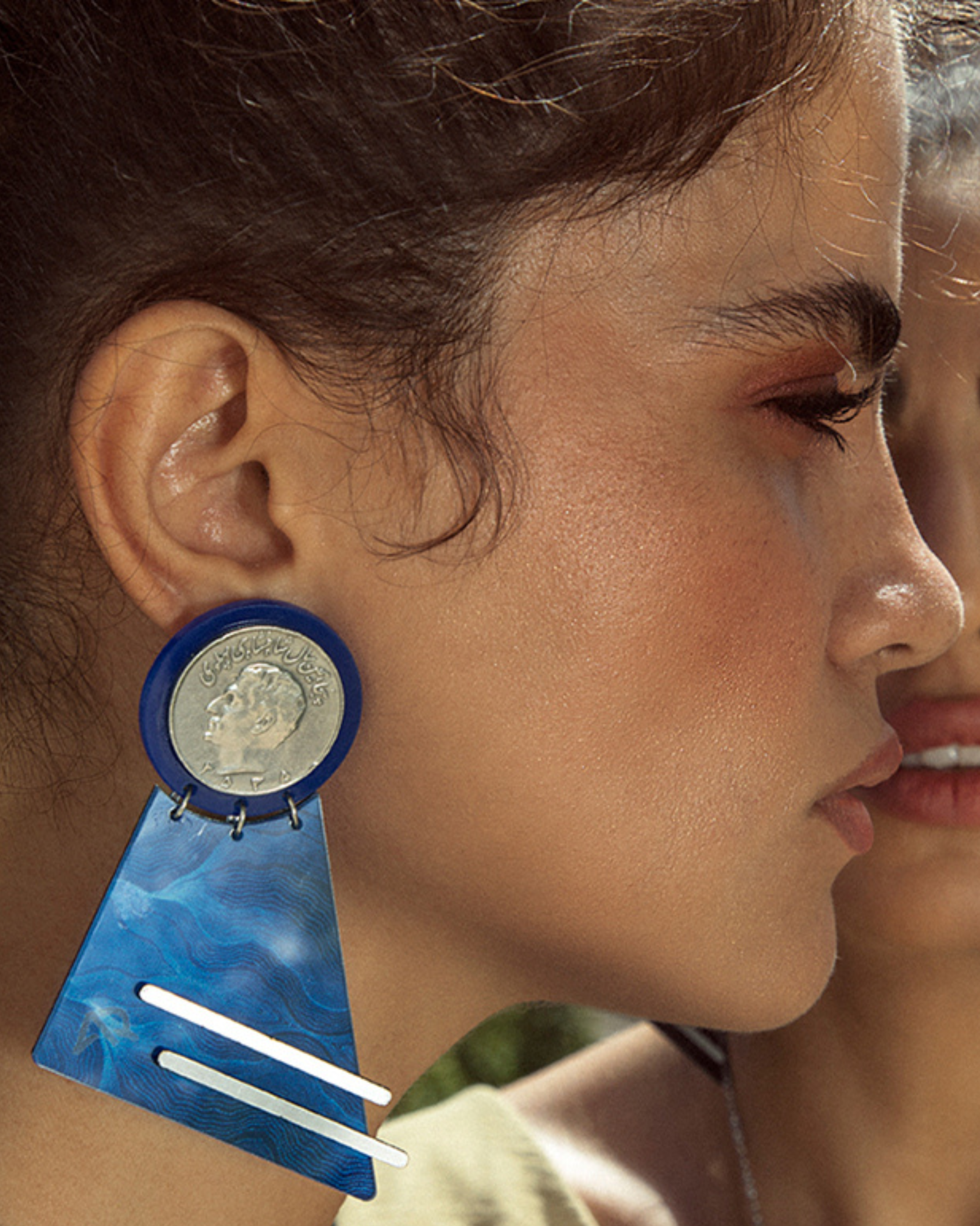 Model wearing bold handcrafted statement earrings inspired by Persian heritage