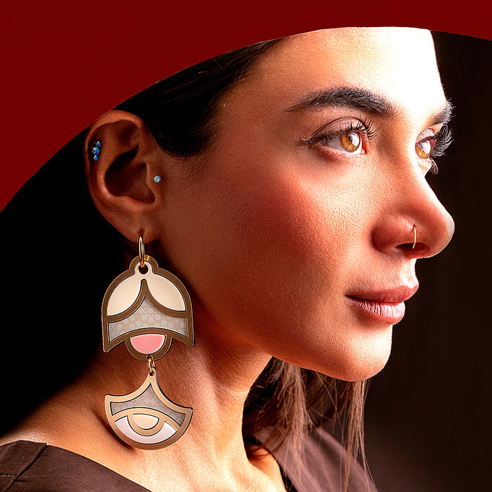 Model wearing large geometric handmade earrings with double-tier drop design