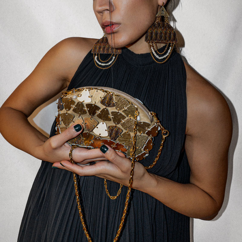 Model holding artisan Persian-inspired designer bag