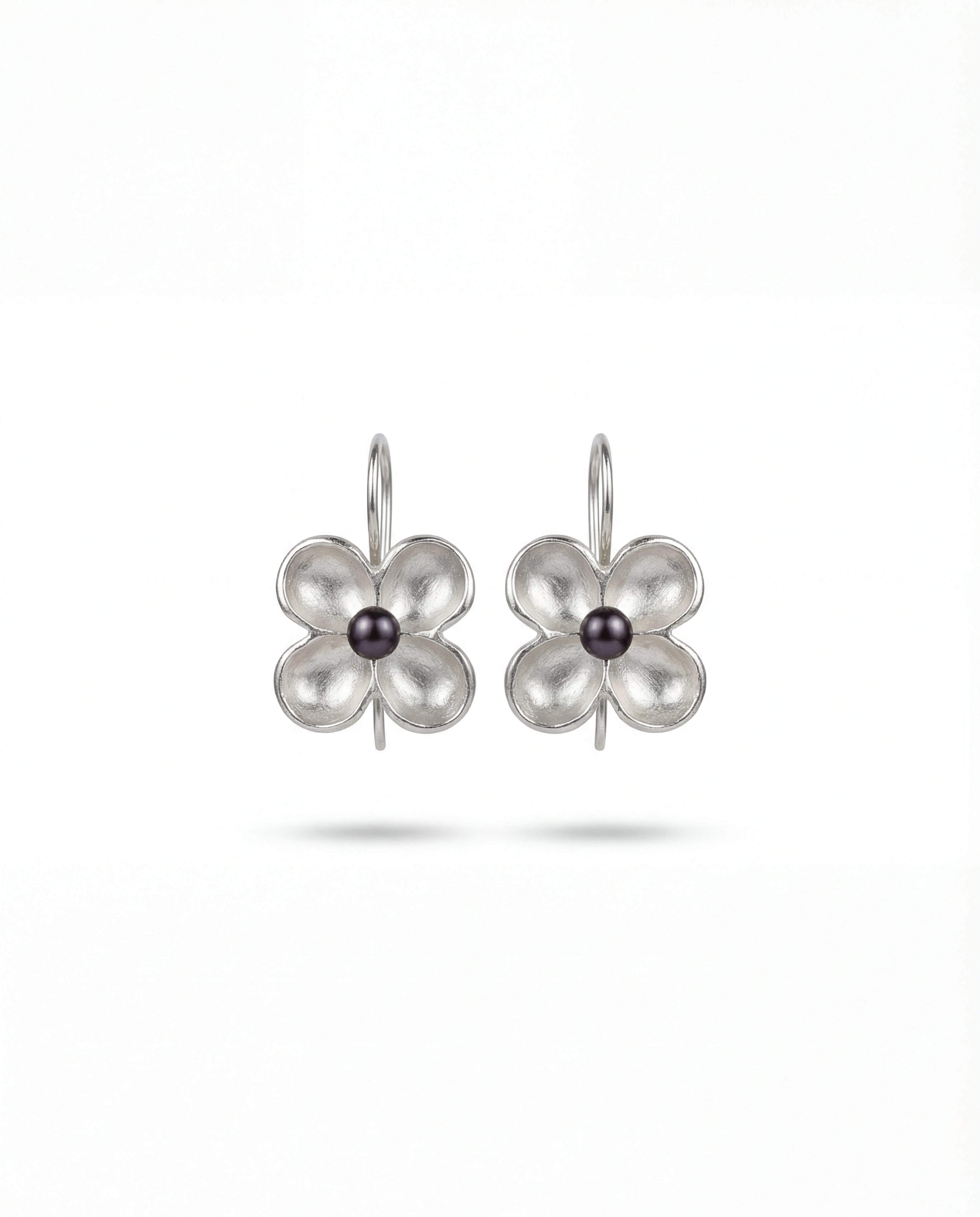 Minimalist pearl center silver earrings on neutral background