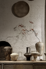 Minimalist handmade vases with dry branches in artistic home setting