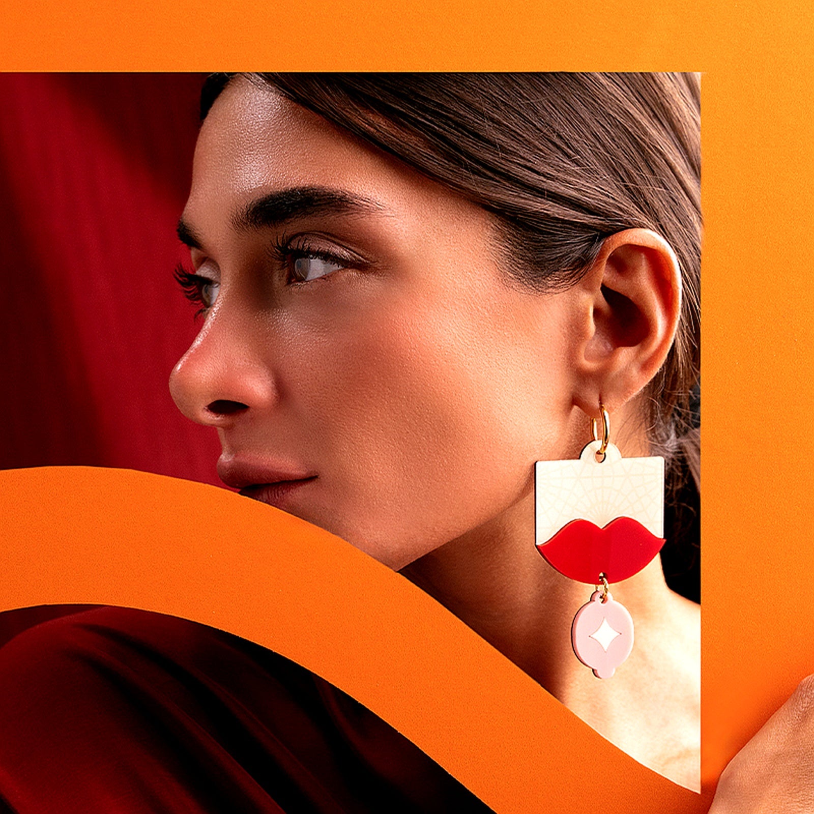 Model wearing lightweight acrylic statement earrings with red lips and gold hoop