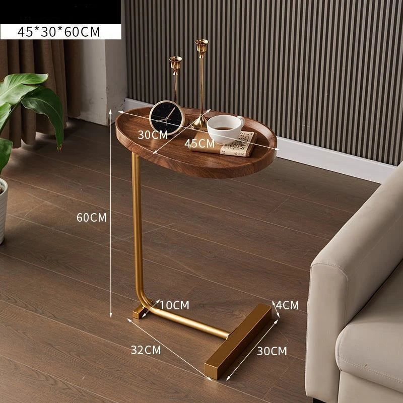 Small wooden side table with gold legs on a wooden floor, showing dimensions.