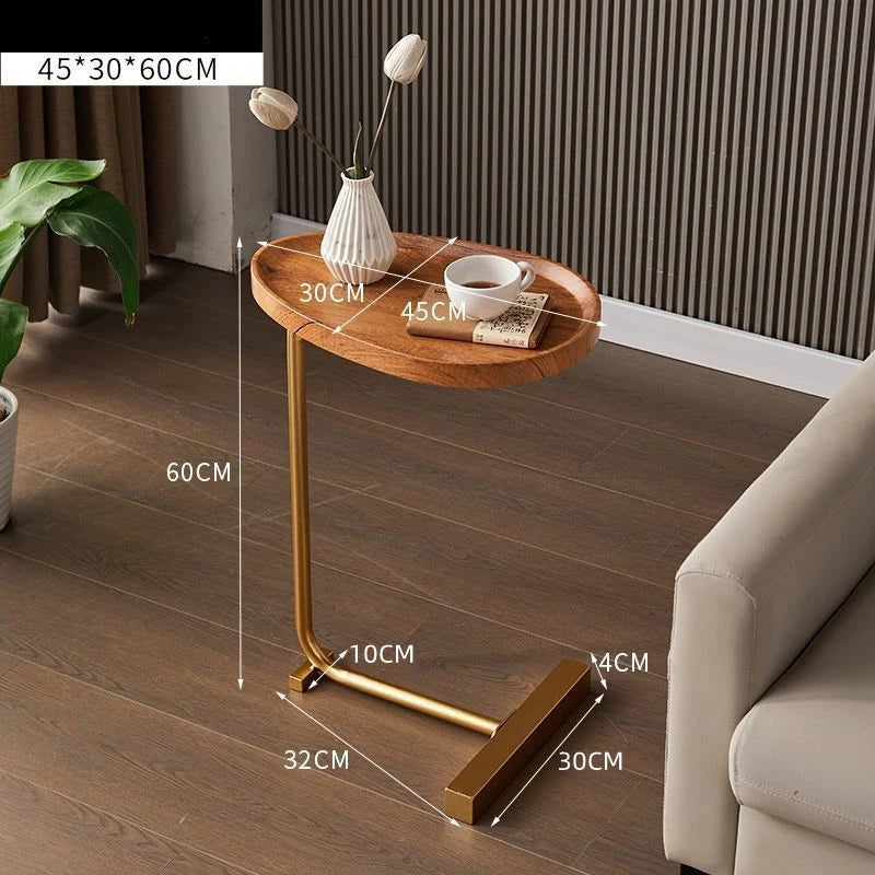 Small wooden side table with gold legs on a wooden floor, dimensions indicated.