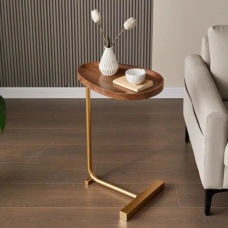 Wooden side table with gold legs in a living room setting
