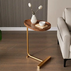 Wooden side table with gold legs in a living room setting