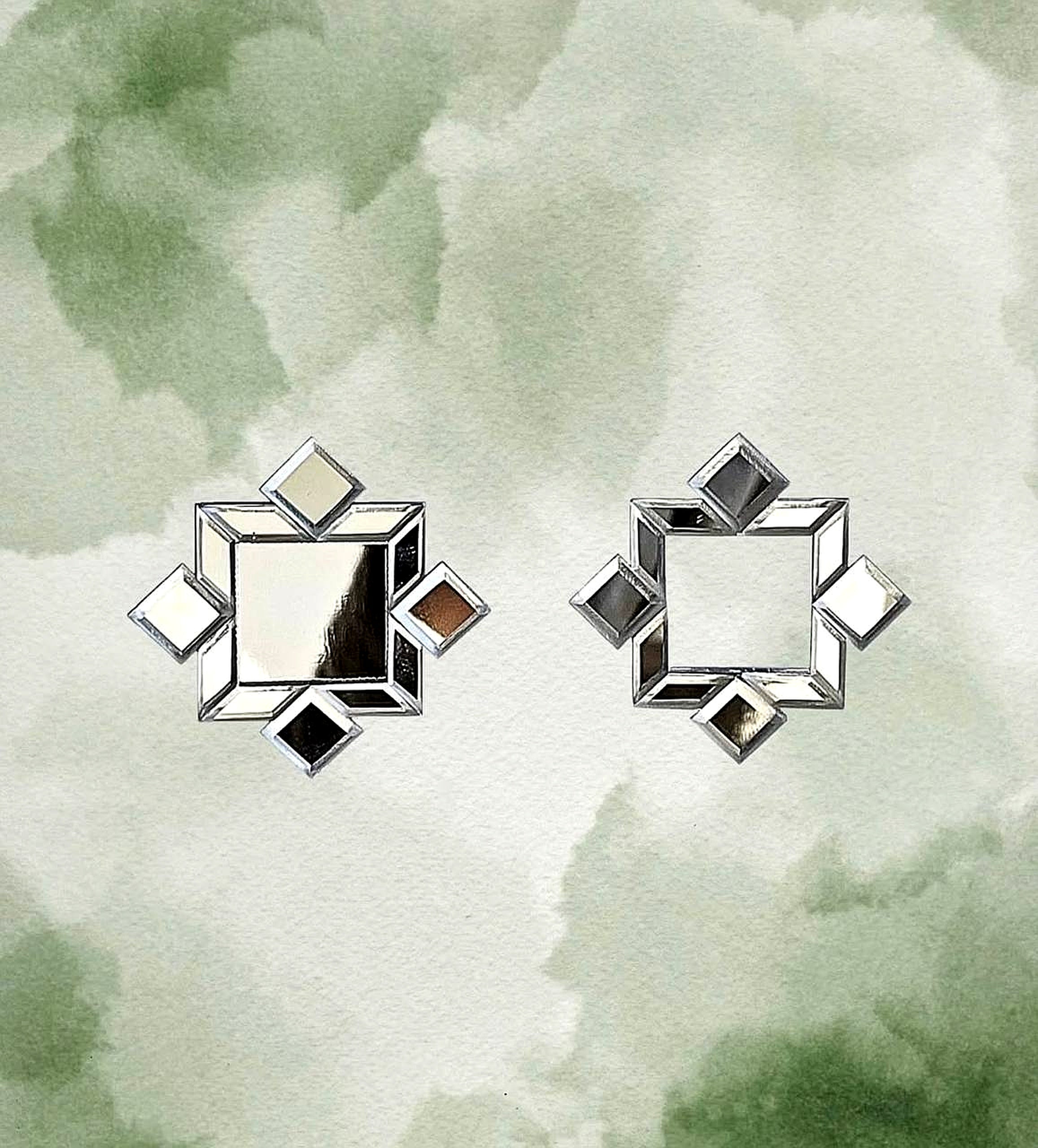 Flat-lay of handcrafted mirror earrings on watercolor background