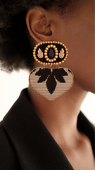 Close-up of embroidered heart earrings with black gemstone worn by model