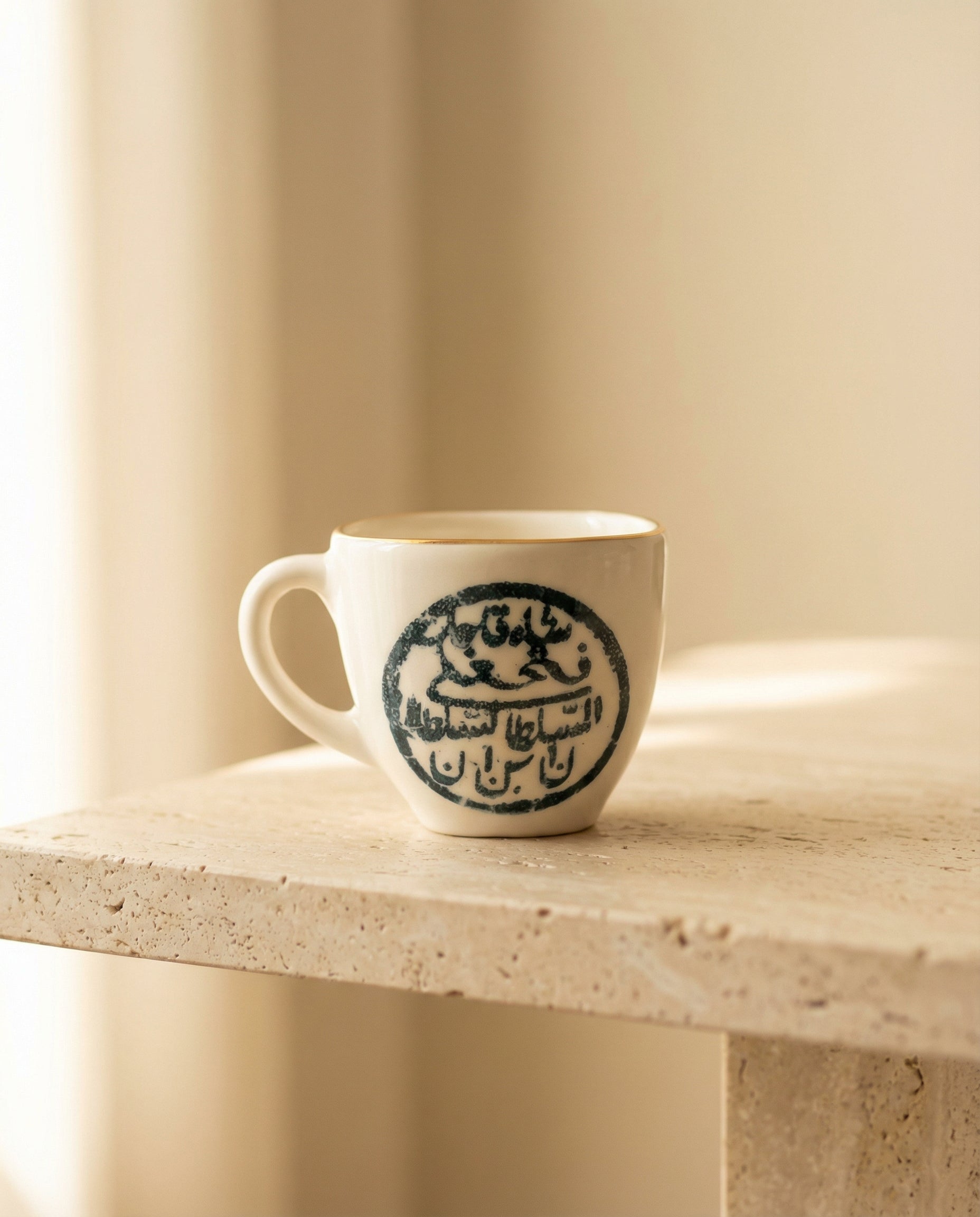 White mug with blue design on a stone surface