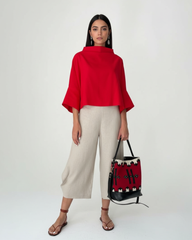 Model wearing beige round-hem linen pants with red linen top
