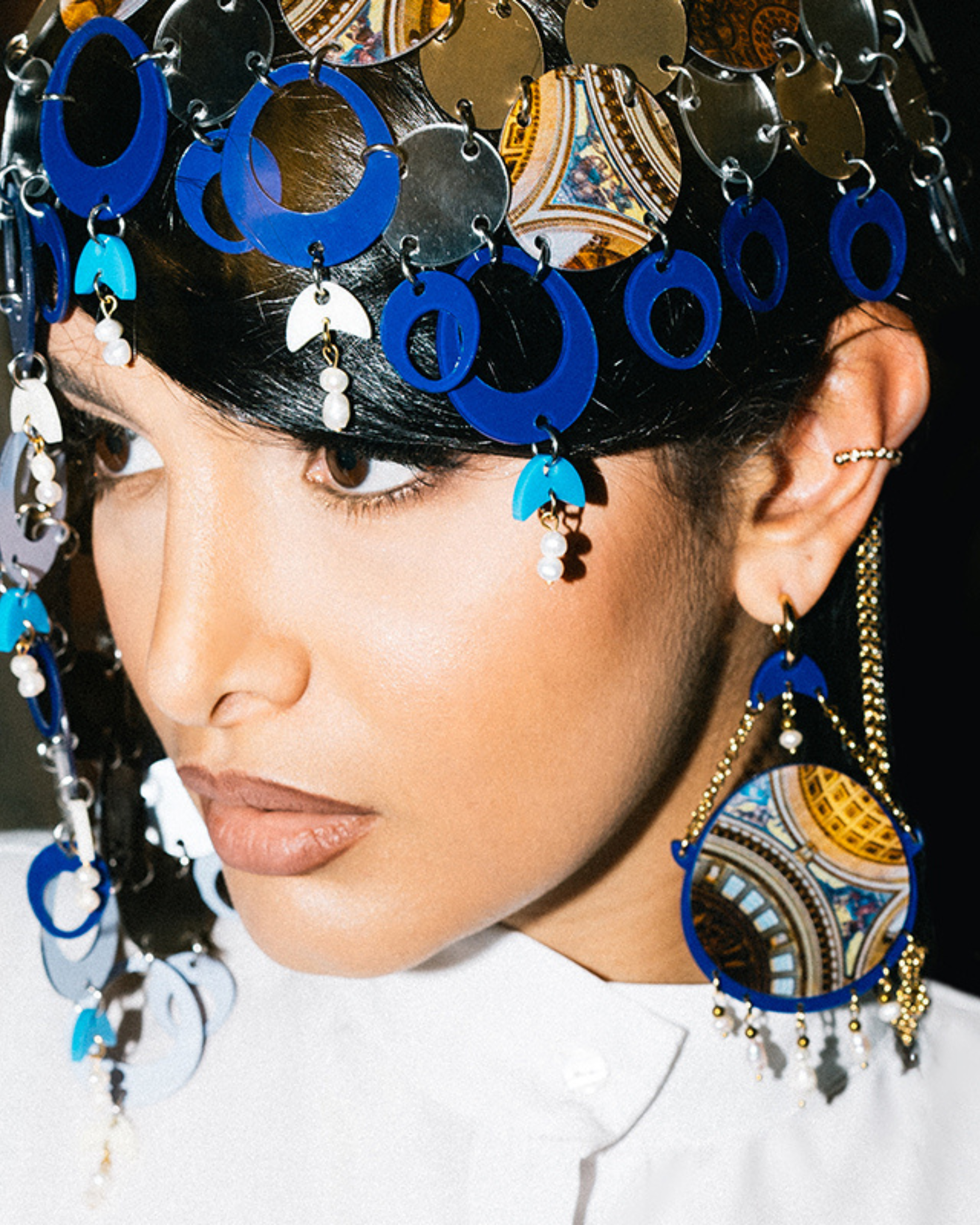 Model wearing statement earrings inspired by Persian architecture