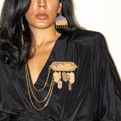 Woman wearing a black outfit with gold brooch 