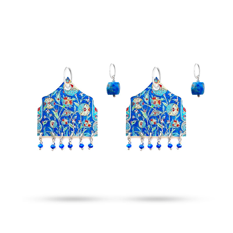 Decorative earrings with floral patterns and blue accents on a white background