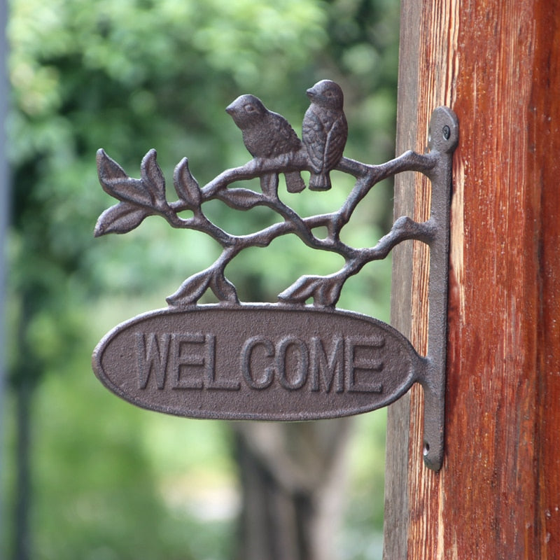 vintage cast iron welcome sign with birds on branch
